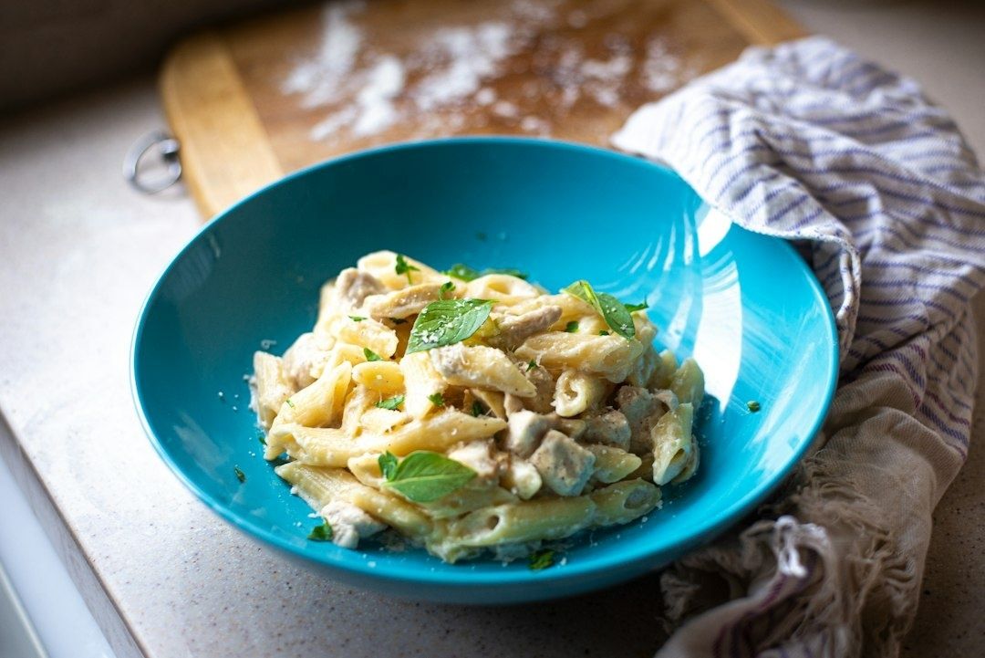 Pennepasta i krämig sås fotograferad i mjukt sidoljus